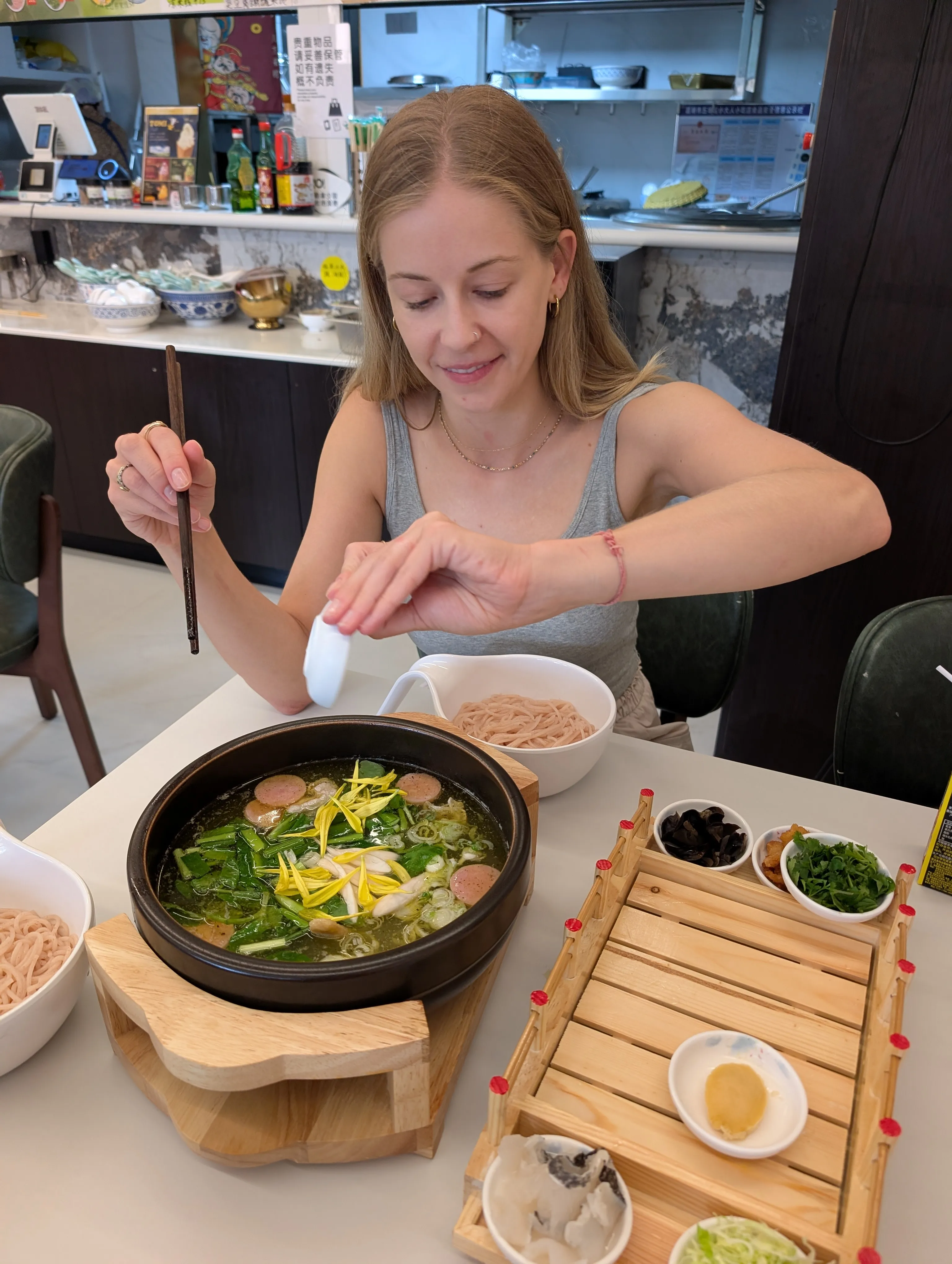 Crossing the bridge noodles, a Yunnan specialty: a scalding bowl of broth with noodles and toppings added tableside.