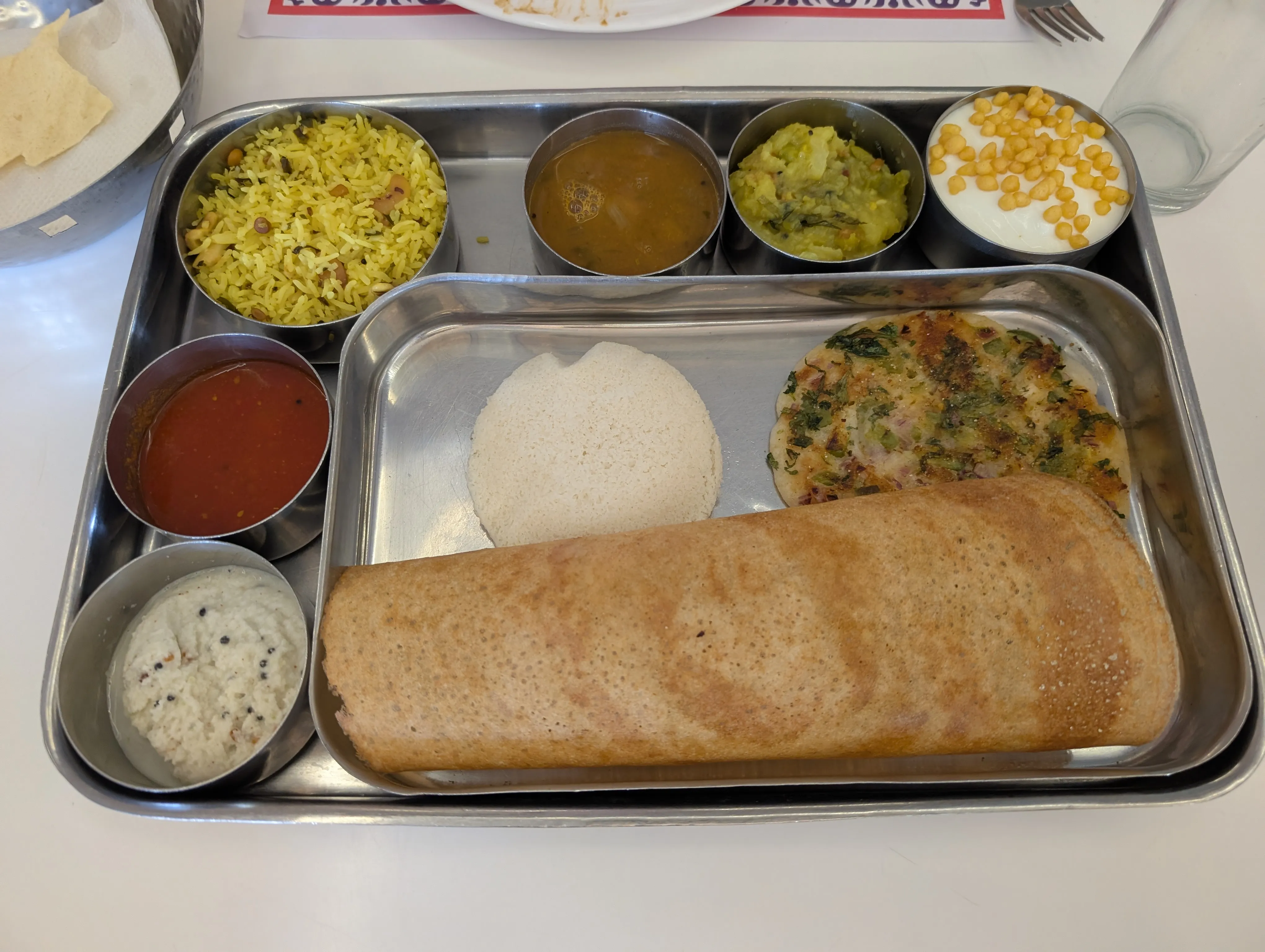 A south Indian breakfast spread: dosa, idli, uttapam, sambar, and an array of chutneys.